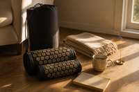 Rolled Bhakti acupressure mat with carry bag, blanket and tea in a cozy living room